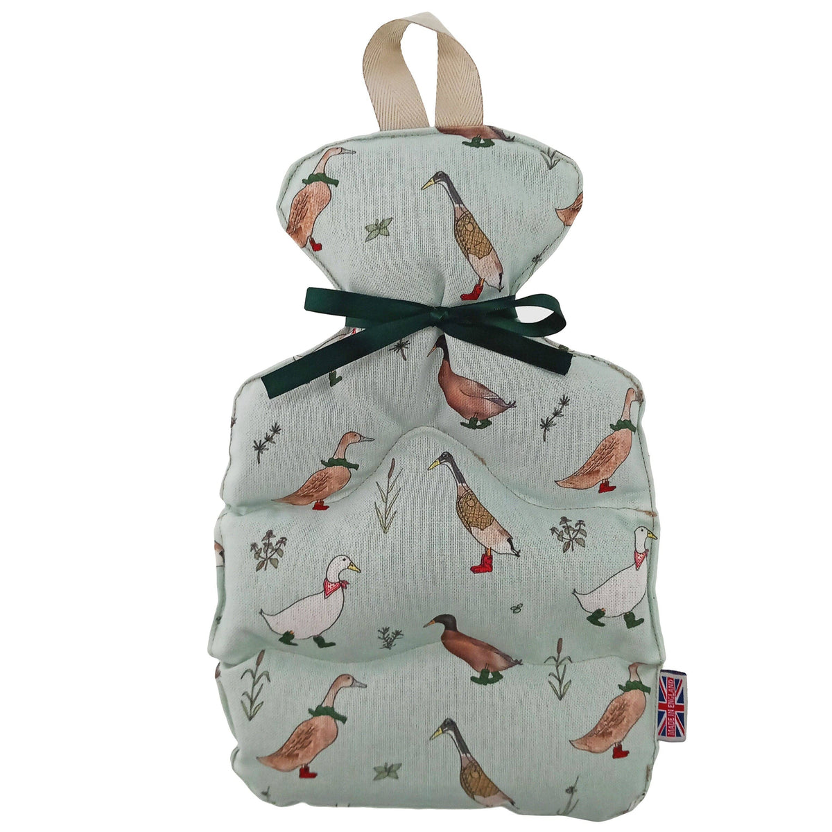 A wheat bottle cover featuring a light sage green linen fabric printed with ducks, a beige hanging loop, and a dark green ribbon tied in a bow in the center. A small Union Jack tag is visible on the bottom right.