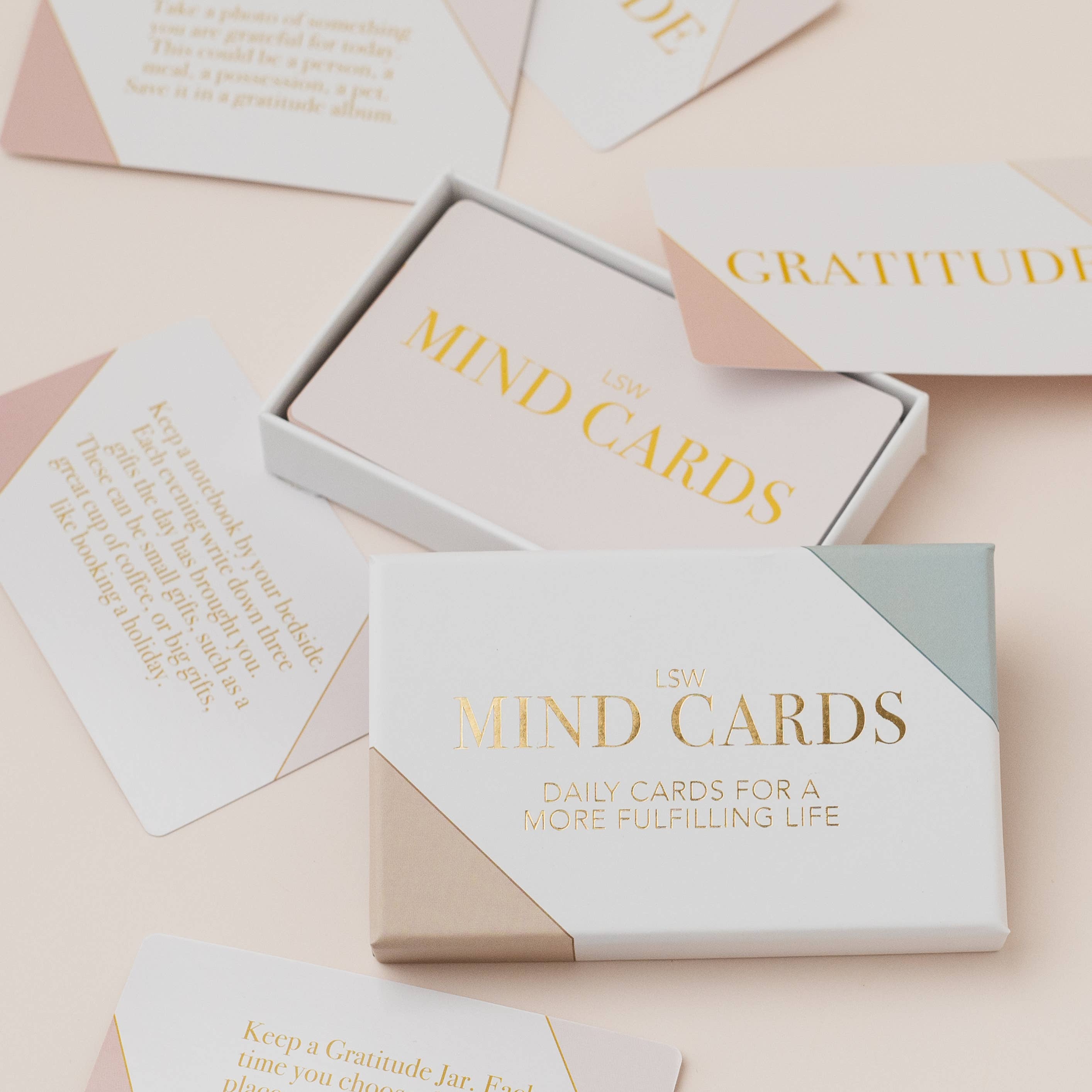 Set of 'MIND CARDS' with 'Gratitude' and 'Daily Cards for a More Fulfilling Life' on a light pink background.