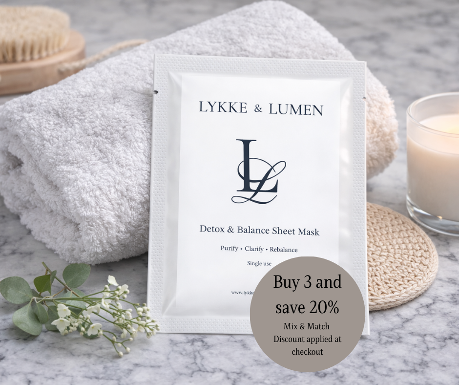 LYKKE & LUMEN detox and balance sheet mask packaging on a marble surface with towel and candle.