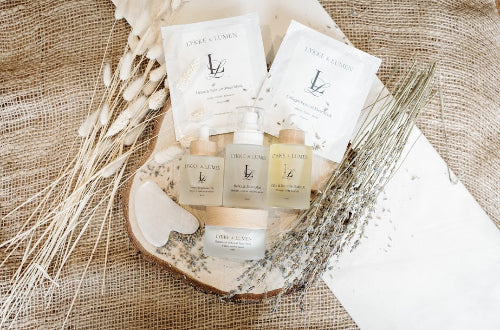 Lykke & Lumen Ritual of Rest botanical skincare collection featuring Overnight Renewal Oil, Relax & Reset Mist, Calm & Restore Body Oil, Radiance & Renewal Face Polish, collagen and detox sheet masks, and a gua sha surrounded by dried botanicals.