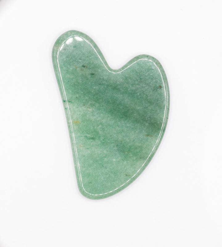 a jade green gua sha on white background