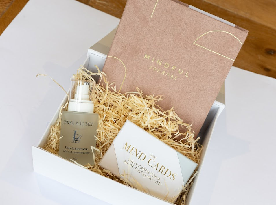 Lykke & Lumen wellness gift set featuring Relax & Reset Mist, mindfulness cards and a mindful journal presented in a luxury self-care gift box with calming natural styling.