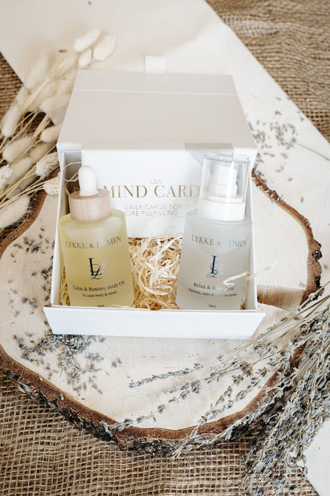 Lykke & Lumen wellness gift set featuring Calm & Restore Body Oil, Relax & Reset Mist and mindfulness cards presented in a luxury white gift box with dried lavender styling.