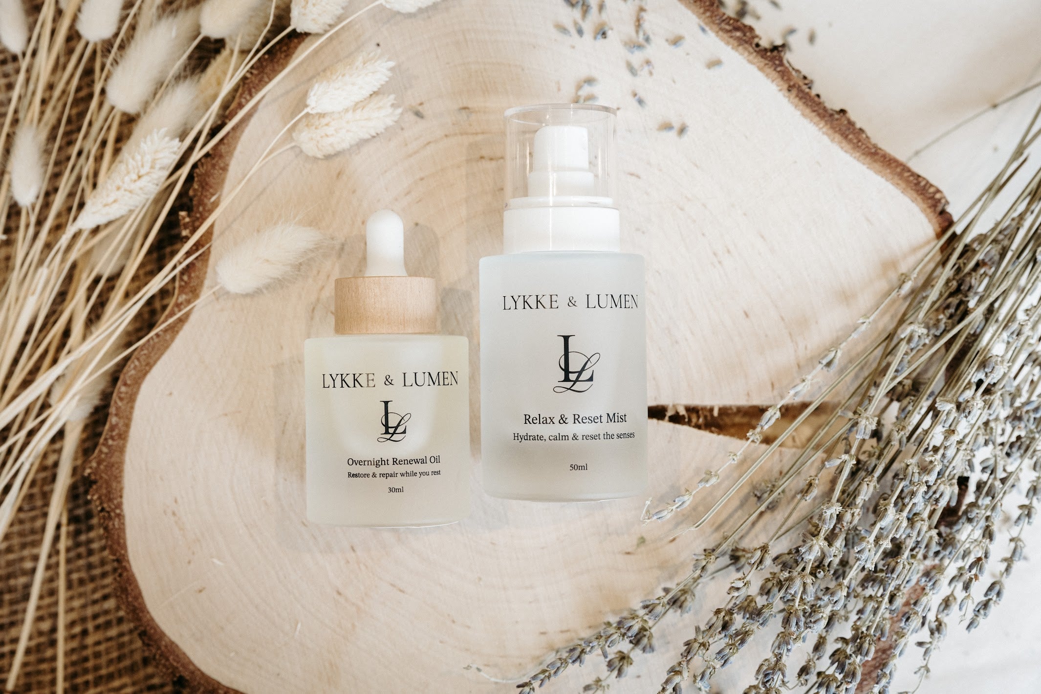 Lykke & Lumen skincare ritual collection featuring Overnight Renewal Oil, and Relax & Reset Mist styled with dried lavender in a calming wellness setting.