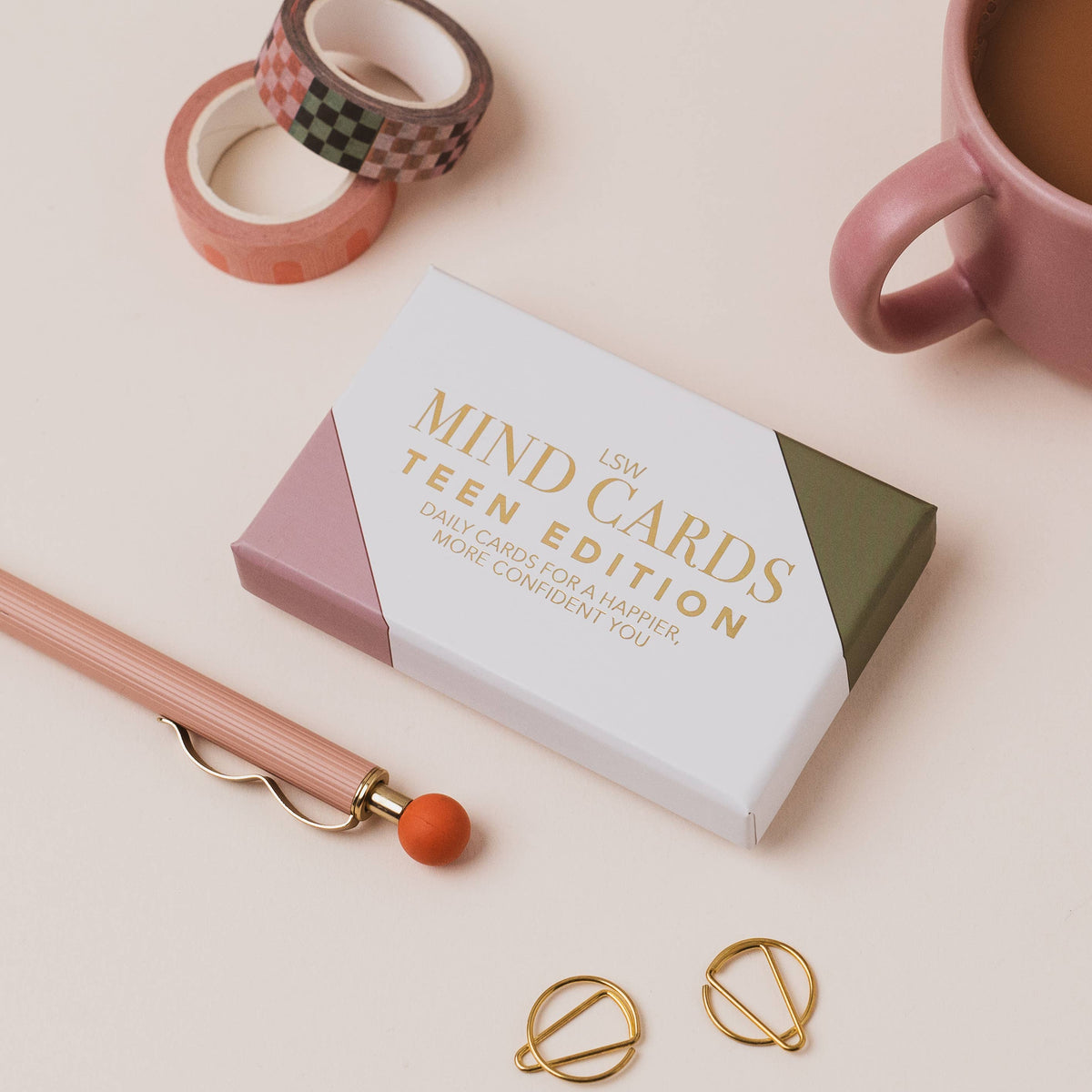 Box of 'MIND CARDS Teen Edition' on a light surface with a pen, tape, and mug.