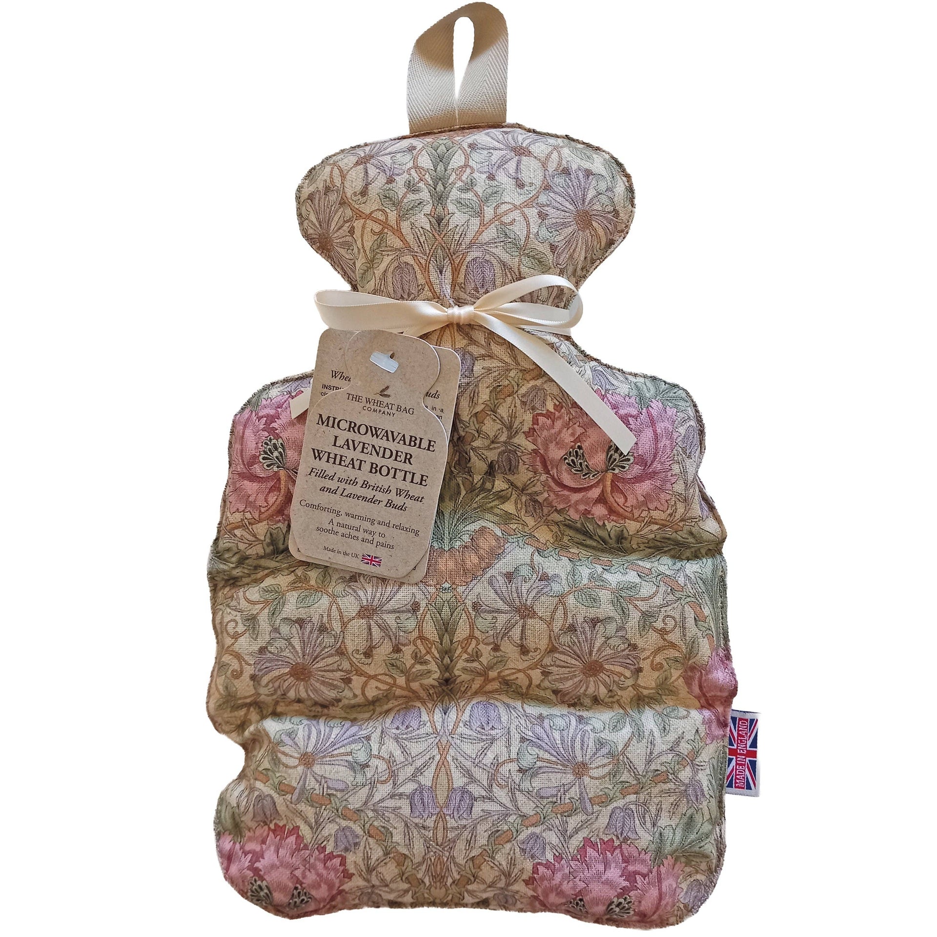 A novelty wheat bottle, featuring a vintage floral and botanical pattern in muted pink, beige, and green tones. It has a coloured hanging ribbon and a paper hangtag that reads 'MICROWALABLE LAVENDER WHEAT BOTTLE'.